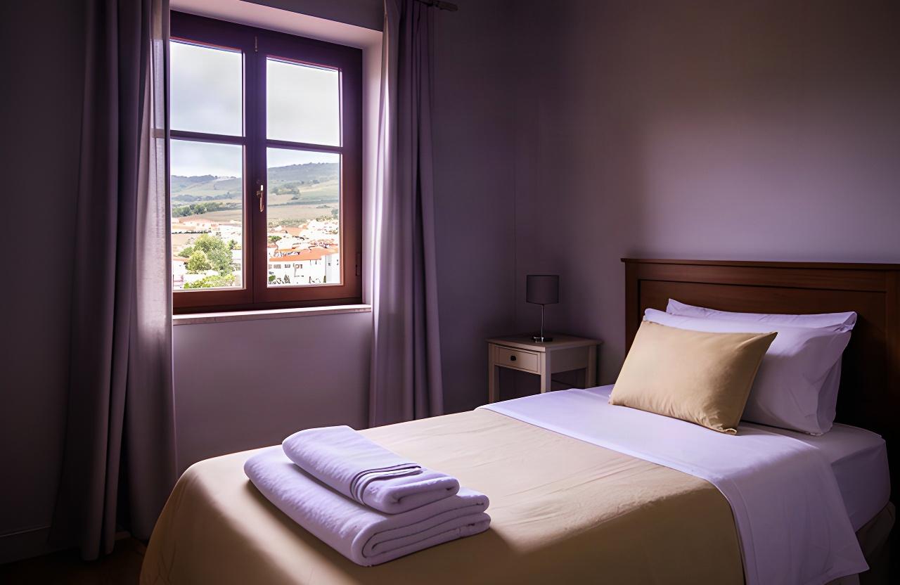 Quarto individual em Arganil com cama preparada e luz natural junto à janela